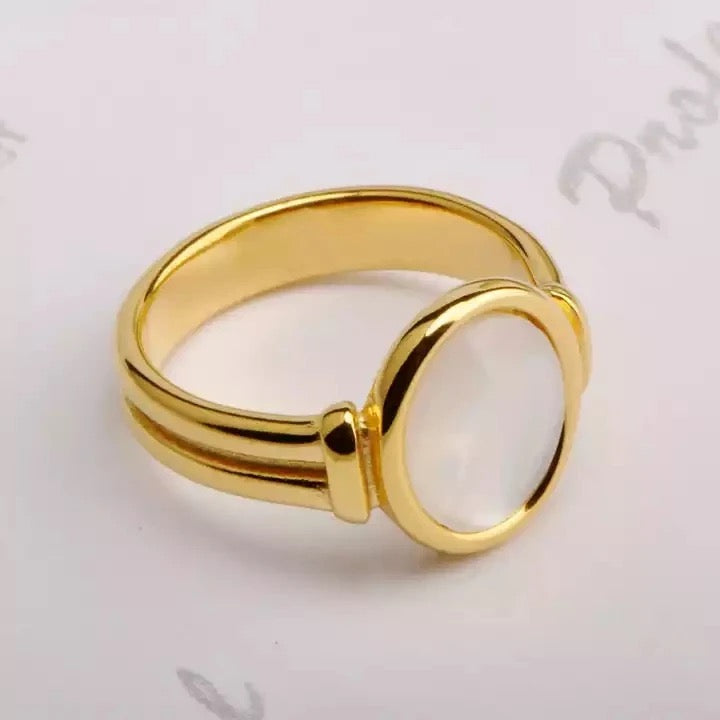 Bague Octavia raffinée en plaqué or 18 carats avec pierre nacrée blanche. Son design élégant et sa finition soignée en font un bijou intemporel et durable.